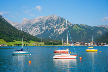 colorful sailboats at lake Achensee,view to tourist resort Pertisau and Karwendel mountains