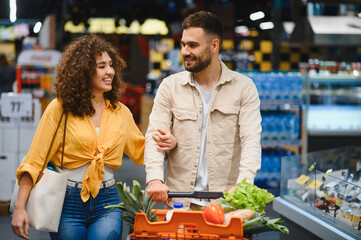 Happy couple shopping for groceries at supermarket