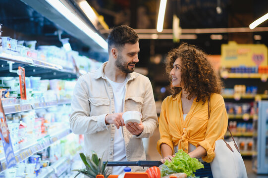 Happy couple grocery shopping together in supermarket - Powered by Adobe