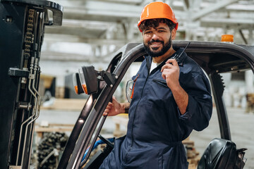 Forklift, machinery to help. Portrait of a male carpenter posing in a woodworking workshop