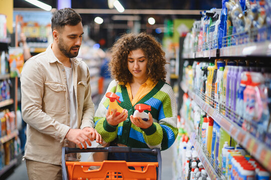 Couple shopping for cleaning supplies in supermarket aisle