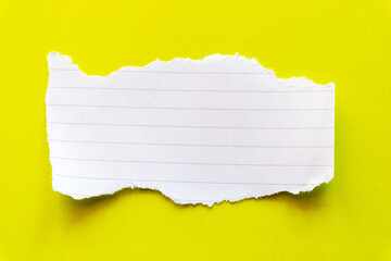 Ripped white paper with lined texture on a bright yellow background. The torn edge creates a contrast between the two colors.