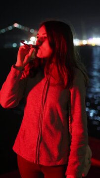 Woman celebrating with party horn blower at night