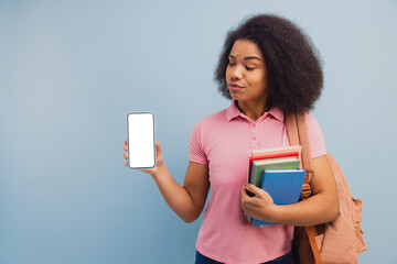 Young student holding phone with books looking skeptical