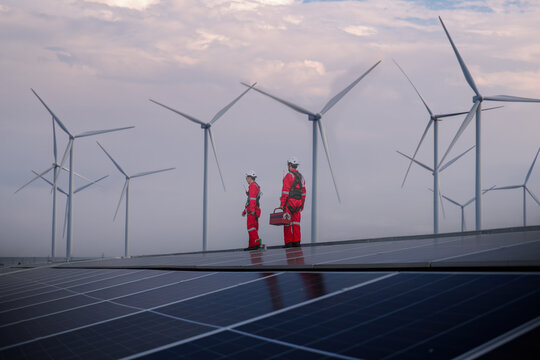 engineer working on solar cell plant with windmill field .Solar cell smart grid and windmill are ecology energy renewable sunlight alternative green power environment factory concep.t