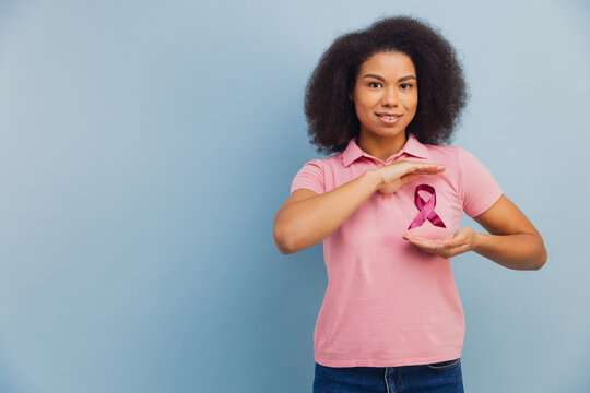 Young african american woman supporting breast cancer awareness - Powered by Adobe