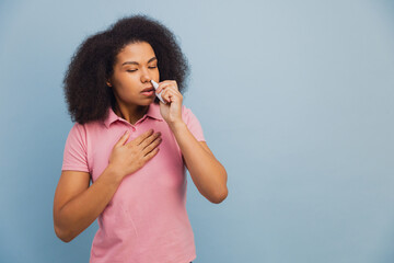 African American woman using nasal spray having allergies