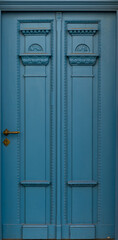 Fototapeta premium Blue carved doors with historic ornament in city facade. Vintage blue doorway.