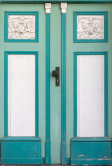 Naklejka premium Mint doors with white stucco on historic facade. Turquoise decorative doors.
