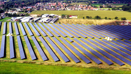Aerial view of a solar farm on green fields, capturing sustainable energy with countless...