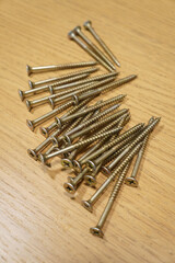 Close-up shot of a pile of wood screws on a wooden surface