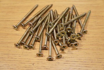 Close-up shot of a pile of wood screws on a wooden surface