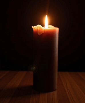 Brown candle burning on wooden surface in dark environment, International Holocaust Remembrance Day  