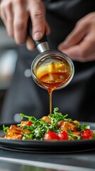 An image of a chef adding sauce to a dish