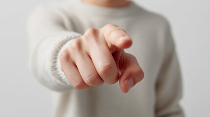 Naklejka premium Close up of a person's hand pointing directly forward wearing a light sweater