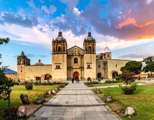 Fototapeta premium Grand stone church and park under a sky with colorful clouds at sunset