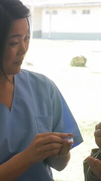 Female doctor helps ederly patient in hospital. Vertical Video