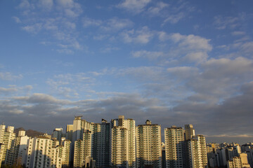 Landscape with a sky with fluffy clouds and an apartment building