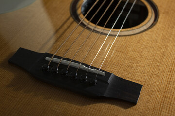 This is a close-up of the strings of an acoustic guitar.