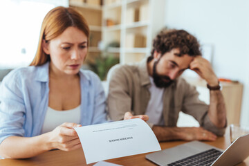 Busy Couple Reviews Document At Home Office Desk In Stressful Moment During Financial Planning Session