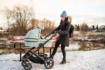 Stroller with brake on. Mother and baby in winter. Pram security. Buggy and carriage safety. Busy...