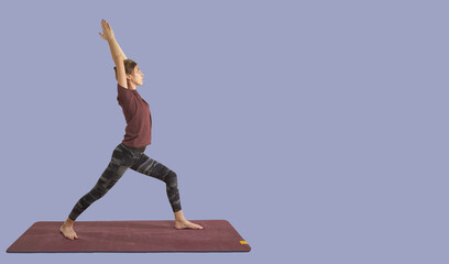 Woman practicing yoga warrior pose on mat