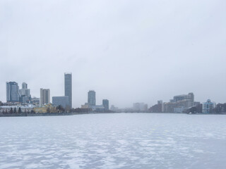 Icy river scene with distant skyline and muted tones under overcast weather conditions