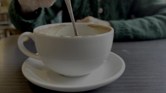 Close up of older person hands only drinking coffee from a cup. Slow motion 120fps in cafe drinking a cup of tea UK 4K