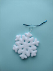 Snowflake Christmas tree toy on a blue background.