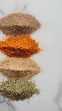 Spices or powders vertically stacked on marble, suitable for food blogs, packaging design, culinary websites, and restaurant menus.
