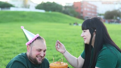 Happy couple celebrating birthday in the park