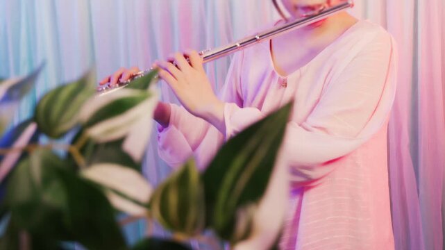 フルートを吹いている人の手元のクローズアップ,
ピンク色の服