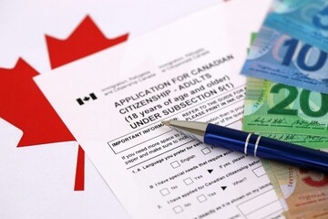 Obraz premium Canadian application for citizenship with money on Canadian flag close up
