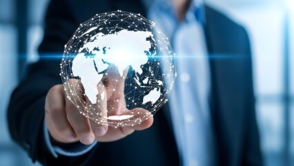 Close-up of a businessman's hand holding a glowing 3D earth model with network connections in a blurred office background.