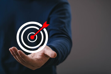 Hand presenting a target icon with red arrow symbolizing goal setting, business focus, strategic planning, achievement, and success direction for marketing, leadership, and growth concepts.