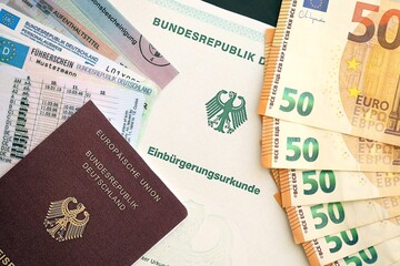 German passport and an identity card on an official naturalization certificate. Symbolic for successful acquisition of German citizenship close up
