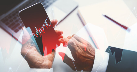 Senior Caucasian businessman in a suit examines a contract using his smartphone in a bright office. He focuses on technology to enhance business productivity and remote work efficiency.