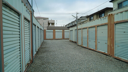 Rental container boxes arranged in Japan, used for storage and organization in urban areas.