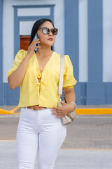 Mujer joven hablando por teléfono móvil al aire libre, enfocada en la comunicación y los...