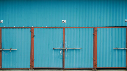 Wall texture of a blue container box warehouse showing industrial metal surface and structural details.