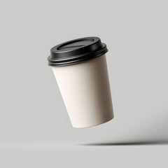 Floating disposable coffee cup with black lid isolated on clean grey background