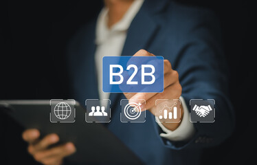 Business to business (B2B) market concept. B2B transactions, exchanging of goods and services between organizations. Businessman showing screen for B2B management by using digital platforms.