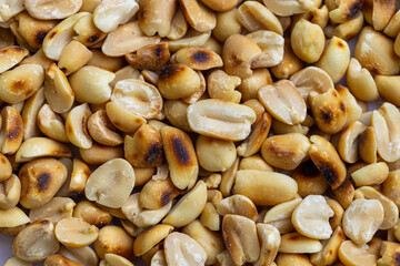 Close-up macro shot of roasted peanuts,Close up shot of roasted salty peanut kernels in a dense pile,Pile of roasted at home peanuts on white 