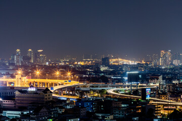 Obraz premium The high angle background of the city view with the secret light of the evening, blurring of night lights, showing the distribution of condominiums, dense homes in the capital community