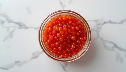 Transparent glass jar with red caviar viewed from above, clean white backdrop.