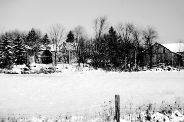 Monochrome of old farm buildings in a winter snow covered landscape