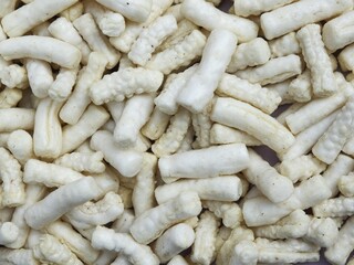 Full-frame, close-up background texture of white, savory Indonesian fish crackers or Krupuk Tengiri. Traditional Asian snack food, crispy, and unhealthy eating.