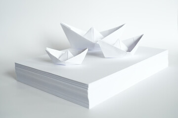 Paper Boats on a Stack of White Paper