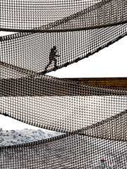 Interesting views of children climbing on the net platform in the children's playground