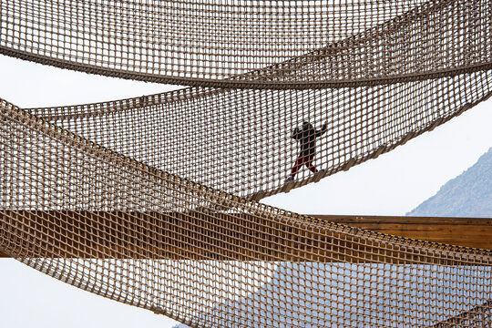 Interesting views of children climbing on the net platform in the children's playground - Powered by Adobe